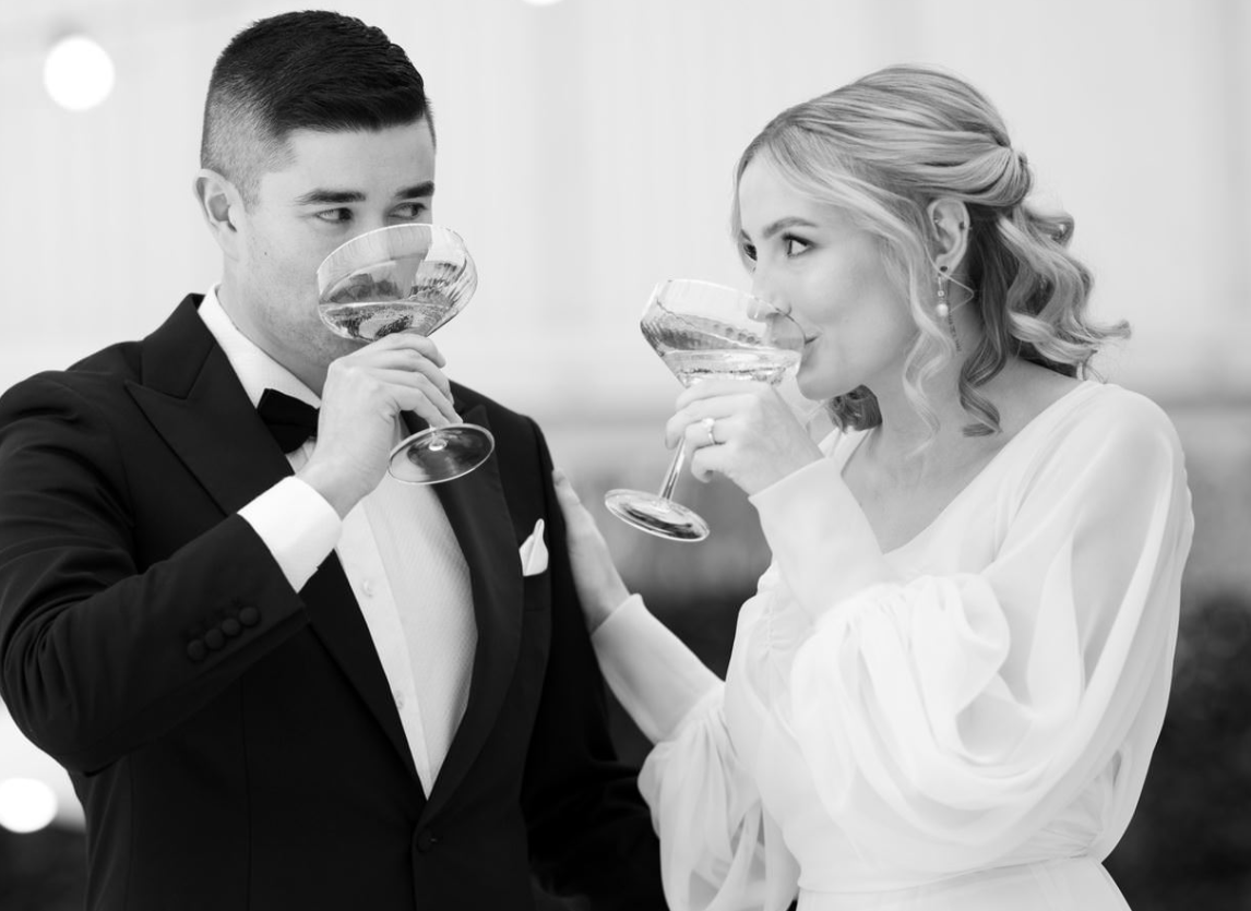 norman yap new married couple looking at each other drinking champagne