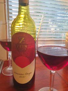 Zein Estate Noveau Rouge wine bottle sitting on a table next to a wine glass