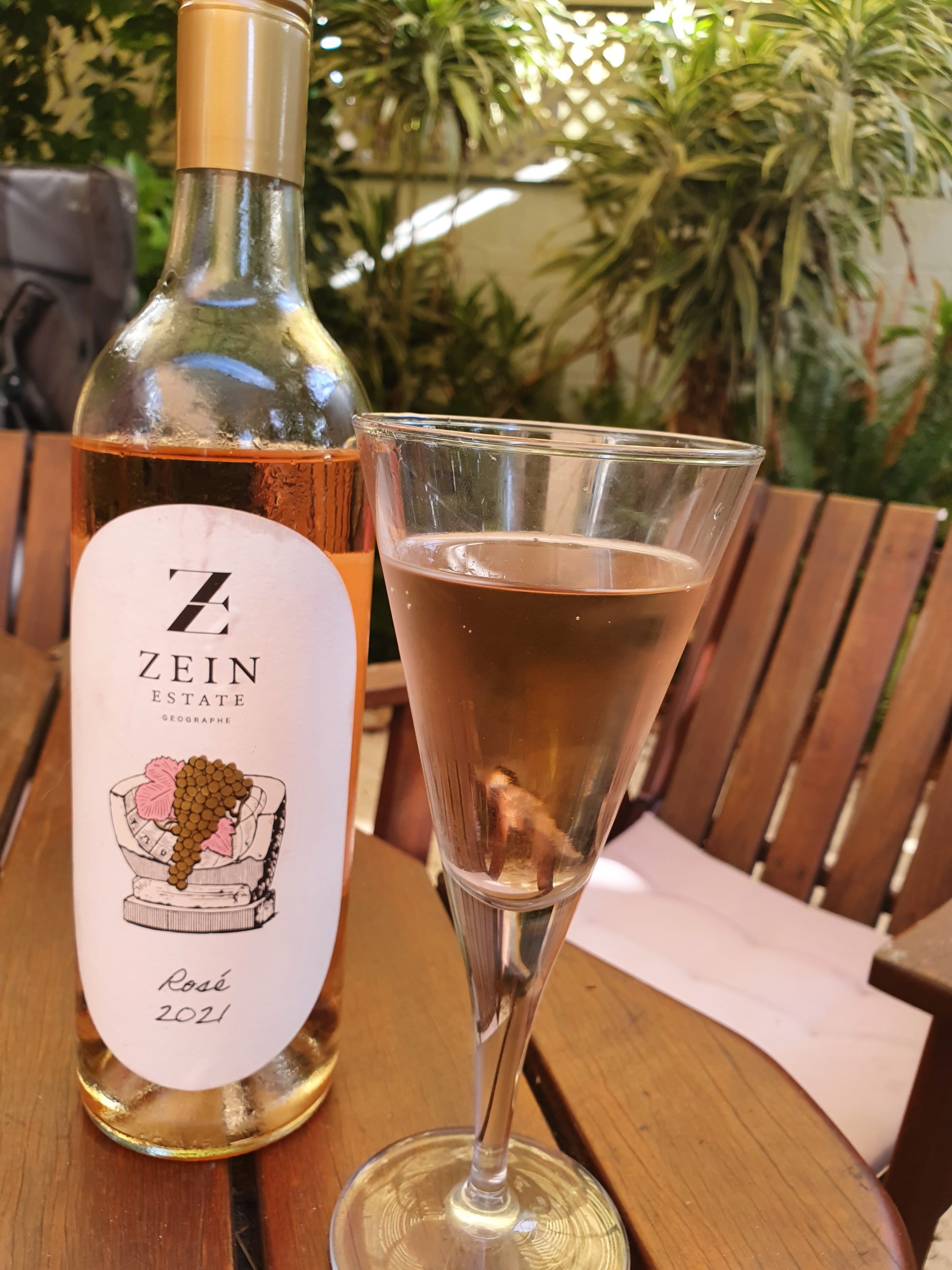 Zein Estate Rose wine bottle sitting on a table next to a wine glass