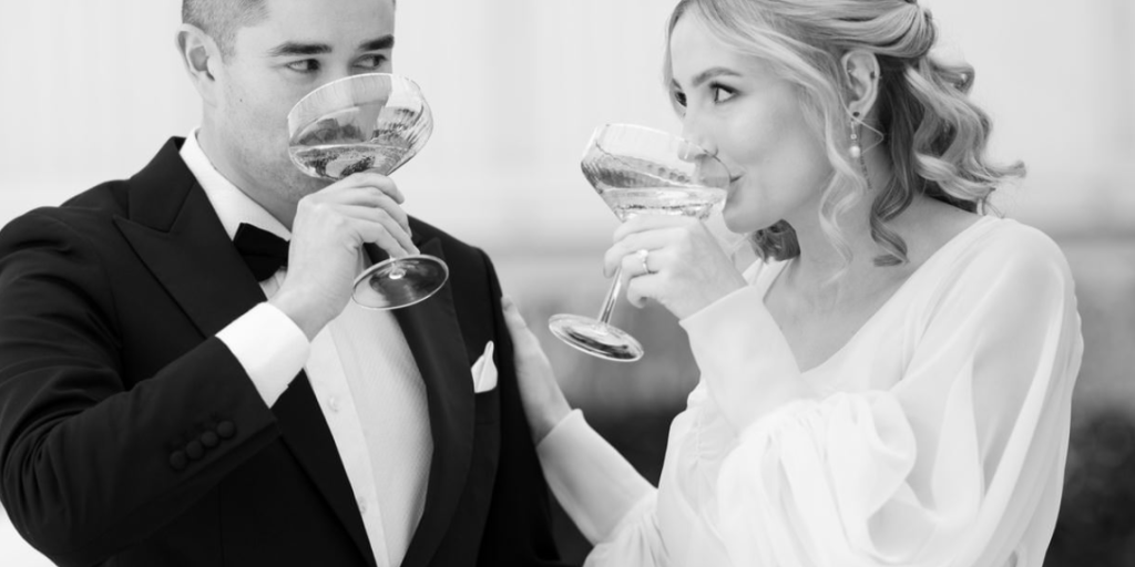 norman yap new married couple looking at each other drinking champagne